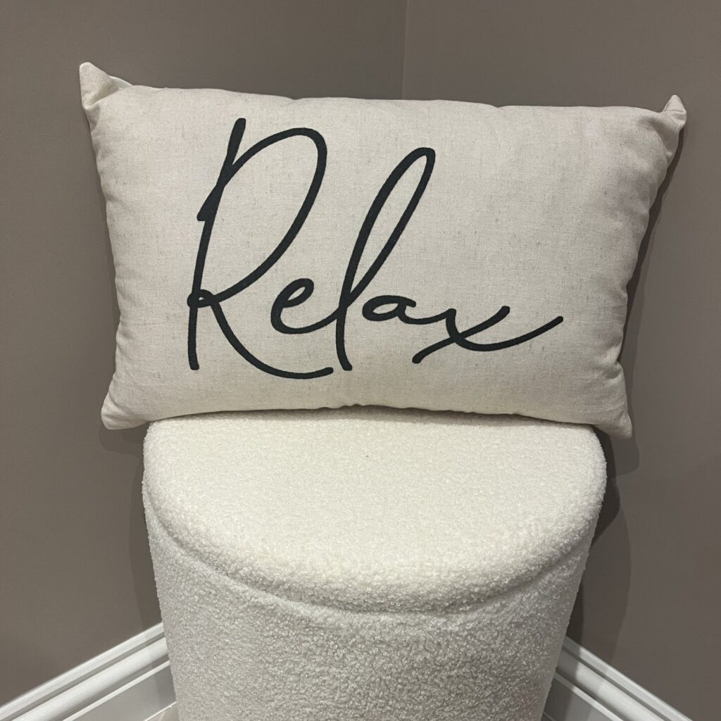 Cream cushion with the word Relax written on it